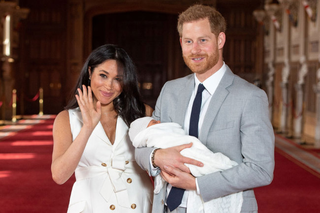 Britain's Prince Harry, Duke of Sussex (R), and his wife Meghan, Duchess of Sussex, pose for a photo with their newborn baby son, Archie Harrison Mountbatten-Windsor, in St George's Hall at Windsor Castle in Windsor, west of London on May 8, 2019. [Photo: AFP]