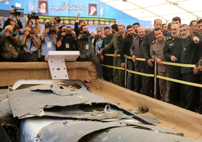 Iranian Revolutionary Guards commander Major General Hossein Salami (2-R) and General Amir Ali Hajizadeh (R) head of Iran's Revolutionary Guards aerospace division, looks at debris from what Iran presented as a downed US drone reportedly recovered within Iran's territorial waters, at Tehran's Islamic Revolution and Holy Defence museum during the unveiling of an exhibition of what Iran says are US and other drones captured in its territory, in Tehran on September 21, 2019. [Photo: AFP/Atta Kenare]