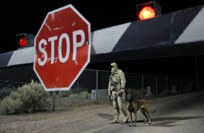 A security guard stands at an entrance to the Nevada Test and Training Range near Area 51 Friday, Sept. 20, 2019, near Rachel, Nev. People gathered at the gate inspired by the "Storm Area 51" internet hoax. [Photo: AP/John Locher]