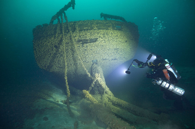 In this Aug. 24, 2019, photo provided by John Janzen, diver John Scoles maneuvers around the wreckage of the schooners Peshtigo and St. Andrews, lost in 1878 near Beaver Island in northern Lake Michigan. [Photo: AP/John Janzen]