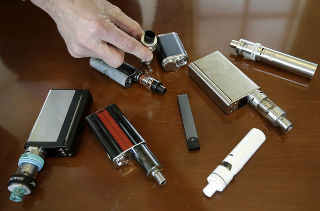 In this Tuesday, April 10, 2018 file photo, Marshfield High School Principal Robert Keuther displays vaping devices that were confiscated from students in such places as restrooms or hallways at the school in Marshfield, Mass. [Photo: AP]