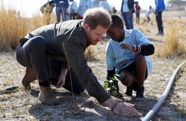 Prince Harry, the Duke of Sussex, helps local school children to plant trees at the Chobe Tree Reserve in Chobe district, in the Northern Botswana on September 26, 2019. [Photo: AFP/Monirul Bhuiyan]