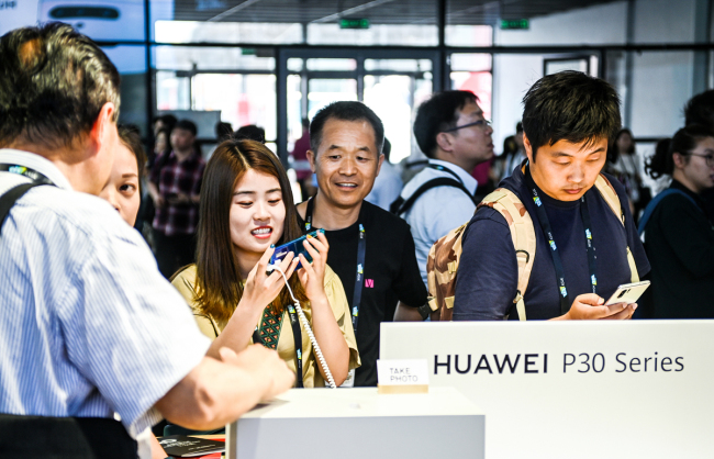 Consumers look at the Huawei P30 series smartphones in Shanghai on June 11, 2019. [File Photo: VCG]