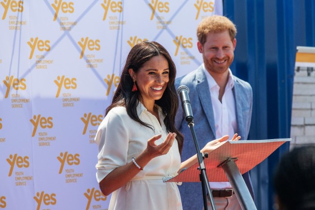 Meghan, Duchess of Sussex (L), is watched by Britain's Prince Harry, Duke of Sussex(R) as she delivers a speech at the Youth Employment Services Hub in Tembisa township, Johannesburg, on October 2, 2019. [Photo: AFP/Michele Spatari]