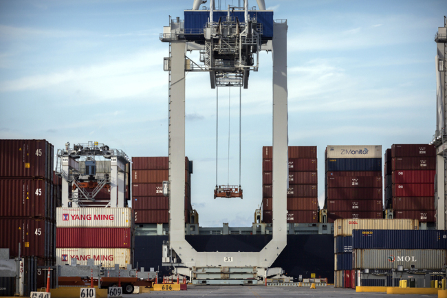 A ship to shore crane prepares to load a 40-foot shipping container onto a container ship at the Port of Savannah in Savannah, Ga., July, 5, 2018. [File photo: AP]