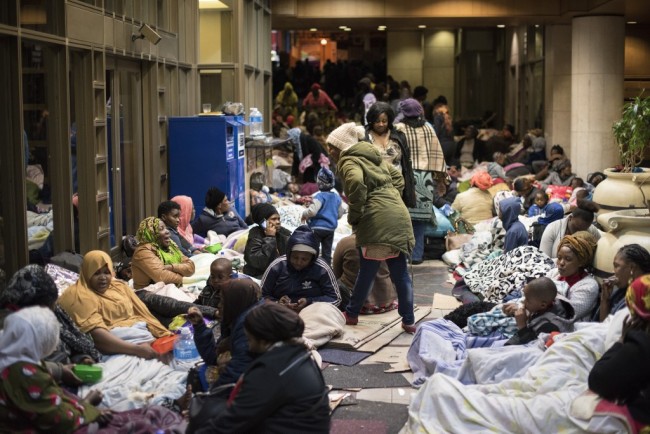 Dozens of people camp in a corridor close to the offices of the United Nations High Commission for Refugees (UNHCR) on October 9, 2019 in Cape Town, demanding to be removed from South Africa saying they were no longer safe. [Photo: AFP]