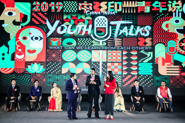 Zhou Heyang and Akhil Parashar from China Media Group speak to Prasanna Shrivastava (middle), the political counselor at the Embassy of India in China, at "China-India Youth Talks 2019" in Beijing on September 28, 2019. [Photo: China Plus]