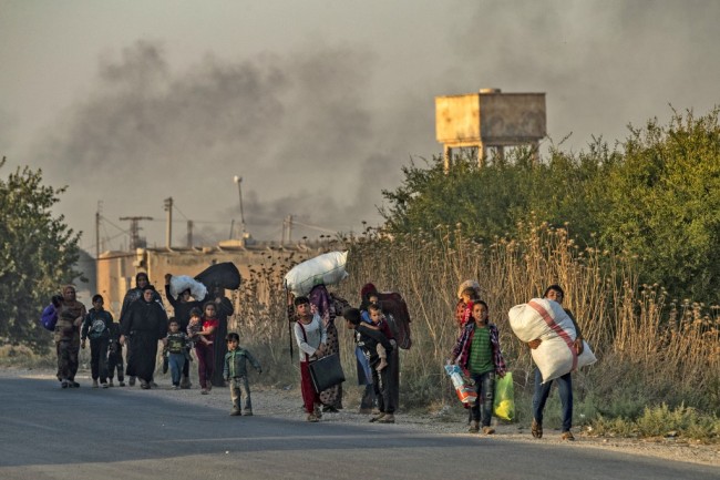 Civilians flee with their belongings amid Turkish bombardment on Syria's northeastern town of Ras al-Ain in the Hasakeh province along the Turkish border on October 9, 2019. [Photo: AFP/Delil Souleiman]