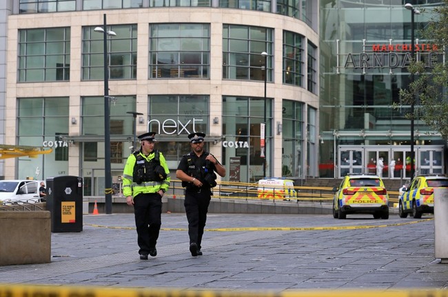 Police officers stand on duty a cordon outside the Arndale Centre shopping complex in Manchester, northwest England on October 11, 2019, following a series of stabbings. Police arrested a man on terror charges Friday after a mass stabbing at a shopping centre in Manchester, northwest England, that left five people injured. [Photo: AFP]