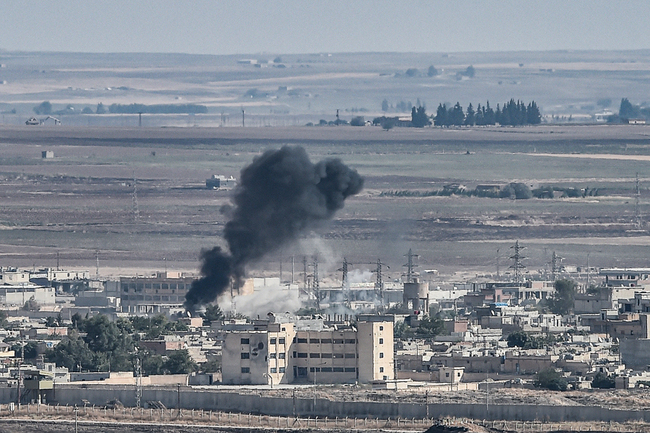 This picture taken on October 13, 2019 from the Turkish city of Ceylanpinar shows smoke rising from the Syrian border town of Ras al-Ain as fighting rages along the border on the fifth day of a Turkish offensive in Syria against the Kurdish People's Protection Units (YPG) that has provoked an international outcry and left dozens of civilians and fighters dead. [Photo: AFP/Ozan Kose]