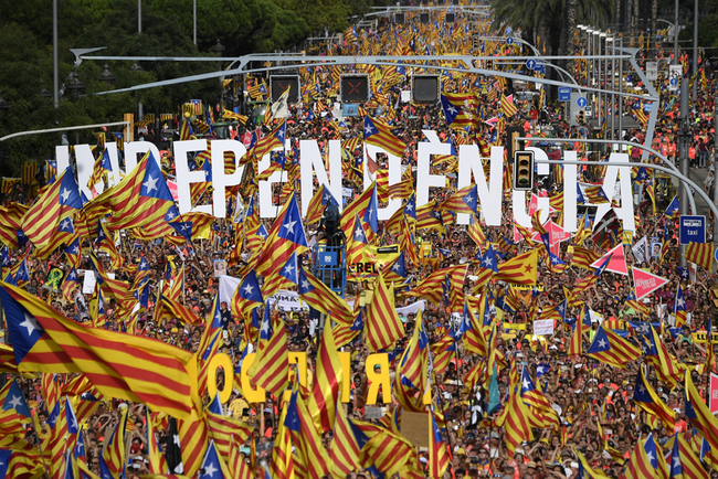 (FILES) In this file photo taken on September 11, 2018 People wave pro-independence Catalan flags 'Esteladas' while holding letters reading "independence" during a pro-independence demonstration in Barcelona on September 11, 2018 to mark the National Day of Catalonia, the "Diada". [Photo: AFP/Lluis Gene]