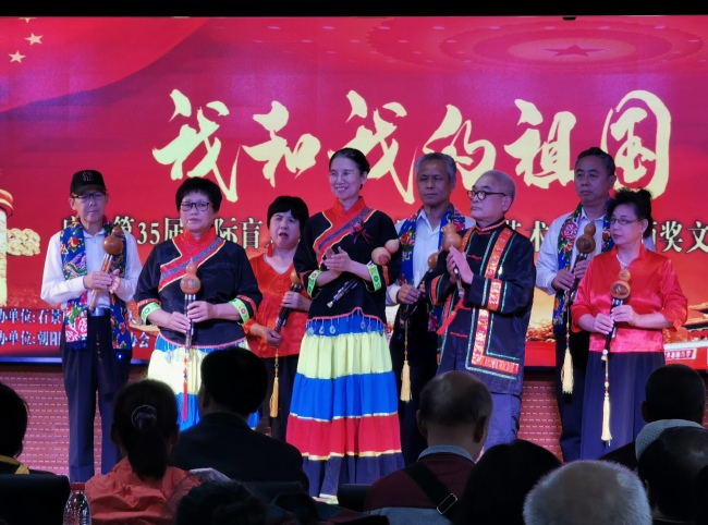 Yang Jia (L4), Li Shiming (R3) and Li's cucurbit flute team perform at a White Cane Safety Day event in Beijing, on October 11, 2019. [Photo: China Plus]