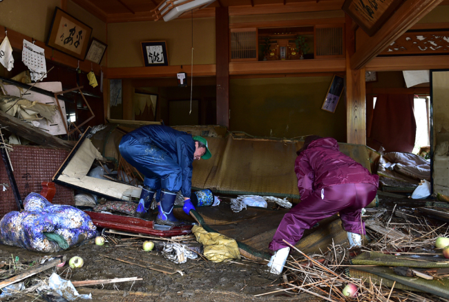 Residents clean their flood-damaged home in Nagano on October 15, 2019, after Typhoon Hagibis hit Japan on October 12 unleashing high winds, torrential rain and triggered landslides and catastrophic flooding. [Photo: AFP/Kazuhiro Nogi]