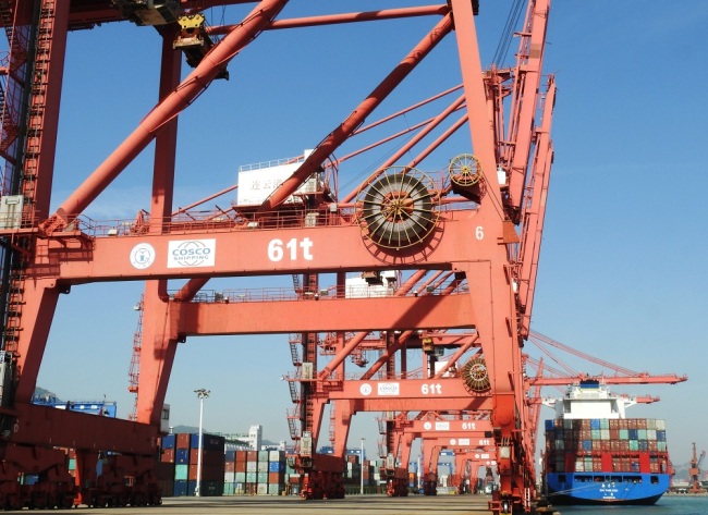 A crane vehicle lifts a container to be shipped abroad from a truck on a quay at the Port of Lianyungang in Lianyungang City, east China's Jiangsu Province, May 8, 2019. [File Photo: IC]