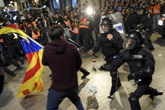 Police clashes with protesters during a demonstration called by the local Republic Defence Committees (CDR), outside the Spanish police headquarters in Barcelona, on October 26, 2019. [Photo: AFP]