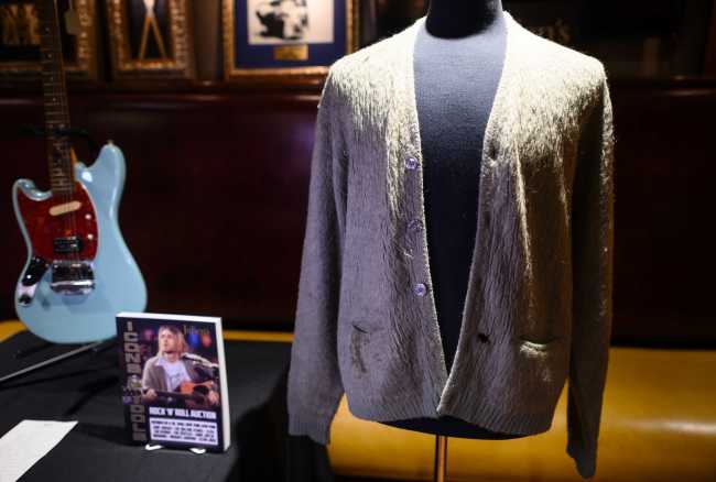 Kurt Cobain's cardigan from Nirvana's 1993 MTV Unplugged performance is on display at the Hard Rock Cafe in New York City ahead of the auction of Julien's Auctions on October 21, 2019 in New York City. A quarter century after grunge's enigmatic rhapsodist took his own life, Kurt Cobain's iconic cigarette-singed cardigan worn during Nirvana's 1993 "Unplugged" performance is up for sale. The tattered faded green button-up sweater with dark stains and a burn hole could go for at least $200,000 to $300,000, according to pre-bidding estimates from Julien's Auctions, which says rock and roll memorabilia has become a major investor's market.[Photo: Johannes EISELE/AFP]