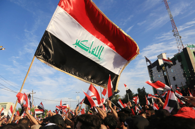 Iraqi protestors wave national flags during a demonstration in the Shiite shrine city of Karbala, south of Iraq's capital Baghdad, on October 25, 2019. [Photo: AFP] 