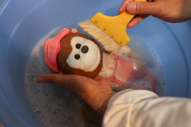 This undated photo shows Zhu Boming washing(清洗 qīngxǐ) a toy at the toy hospital in Shanghai.[Photo: IC]