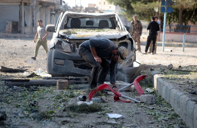 Syrian National Army members inspect the site after an attack with a bomb-laden vehicle carried out by PKK, listed as a terrorist organization by Turkey, the U.S. and the EU, and Syrian Kurdish YPG militia, which Turkey regards as a terror group at the Syrian National Army's headquarter in Tal Abyad, Syria on October 24, 2019. [File Photo: VCG]