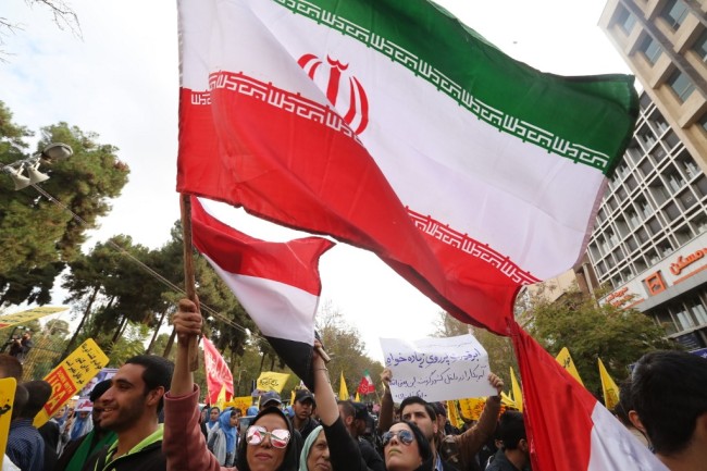 Thousands of Iranian protesters wave national flags during a demonstration outside the former US embassy in the Iranian capital Tehran on November 4, 2019. [Photo: AFP/ ATTA KENARE]