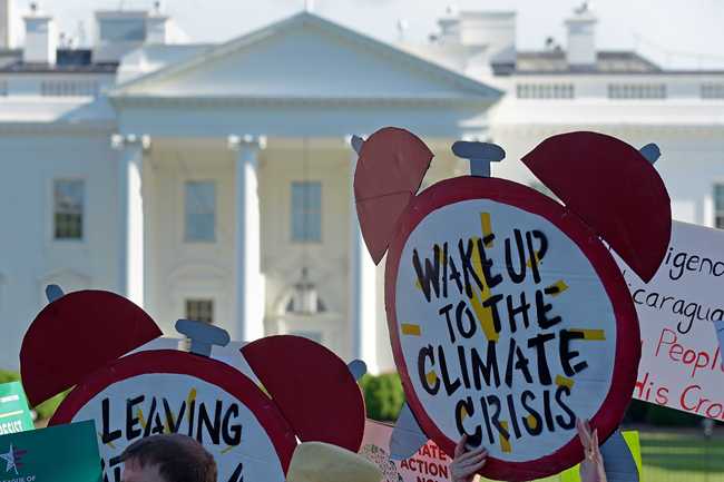 In this June 1, 2017 file photo, protesters gather outside the White House in Washington to protest President Donald Trump's decision to withdraw the Unites States from the Paris climate change accord. [Photo: AP]