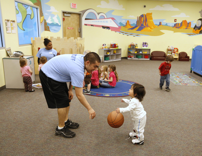 In this file photo, Johnathan Lara, an employee of the child care center at the California Family Fitness center, plays with a toddler at the center in Sacramento, Caiif. [Photo: AP]