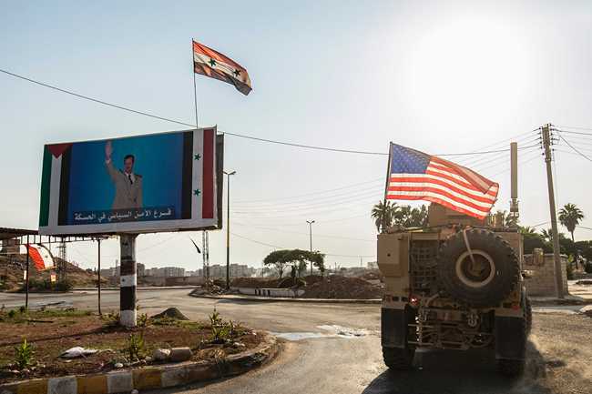 File Photo: A US military vehicle drives near a checkpoint controlled by the Syrian government forces in Syria's northeastern city of Qamishli on October 26, 2019. [Photo: AFP/Delil SOULEIMAN]