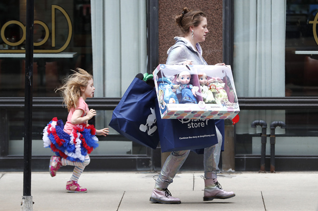 Julia Stamberger, of Chicago, and her daughter Xyla hustle back to her car parked on the street with merchandise purchased Friday, Nov. 29, 2019, in Chicago. Black Friday shoppers fought for parking spots and traveled cross-state to their favorite malls, kicking off a shortened shopping season that intensified the mad scramble between Thanksgiving and Christmas. [Photo: AP/Charles Rex Arbogast]