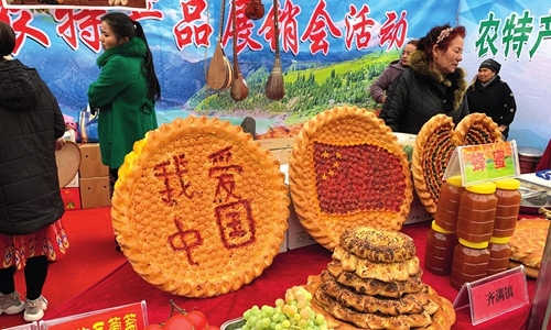 Agricultural products and king-sized pies are displayed at a trade fair in Kuqa County, Xinjiang, on Saturday. [Photo: Li Xuanmin/GT]