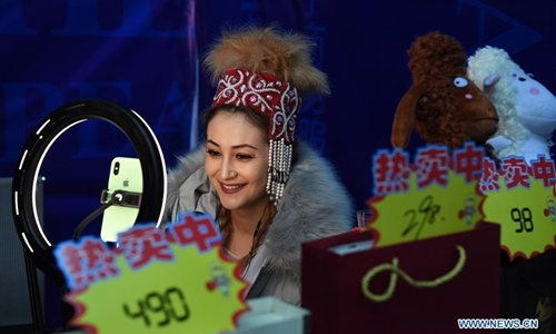 A live-broadcast consultant promotes agricultural products for a company at a fair in a gymnasium in Altay, northwest China's Xinjiang Uygur Autonomous Region, Nov. 27, 2019. The 14th Xinjiang Winter Tourism Trade Fair opened here on Wednesday. [Photo: Xinhua/Sadat]