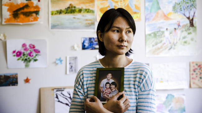 In this May 9, 2018 file photo, Hua Qu, the wife of detained Chinese-American Xiyue Wang, poses for a photograph with a portrait of her family in Princeton, N.J. [File Photo: AP]