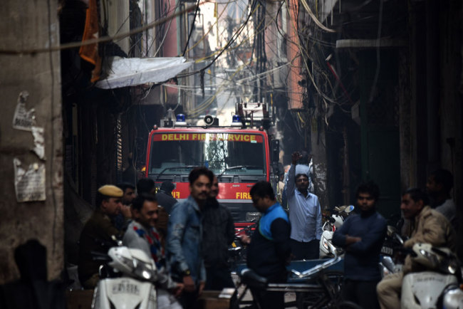 A Delhi Fire Service truck is seen along a street near the site of a factory where a fire broke out, in Anaj Mandi area of New Delhi on December 8, 2019. [Photo: STR/AFP]