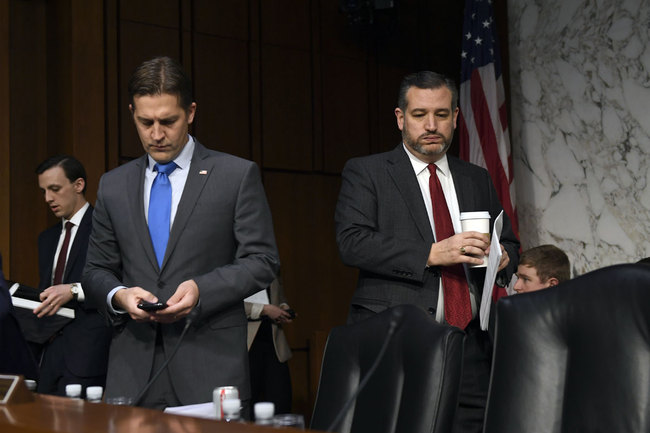 Sen. Ted Cruz, R-Texas, right, arrives for a Senate Judiciary Committee hearing on Capitol Hill in Washington, Wednesday, Dec. 11, 2019, to look at the Inspector General's report on alleged abuses of the Foreign Intelligence Surveillance Act. Sen. Ben Sasse, R-Neb., looks at his phone at left. [Photo: AP]