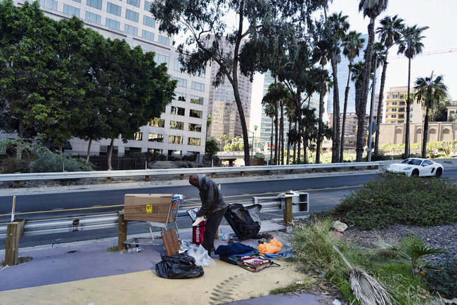 A homeless man who would only give the name David organizes his belongings along an offramp in downtown Los Angeles on Monday, Dec. 16, 2019. [Photo: AP]