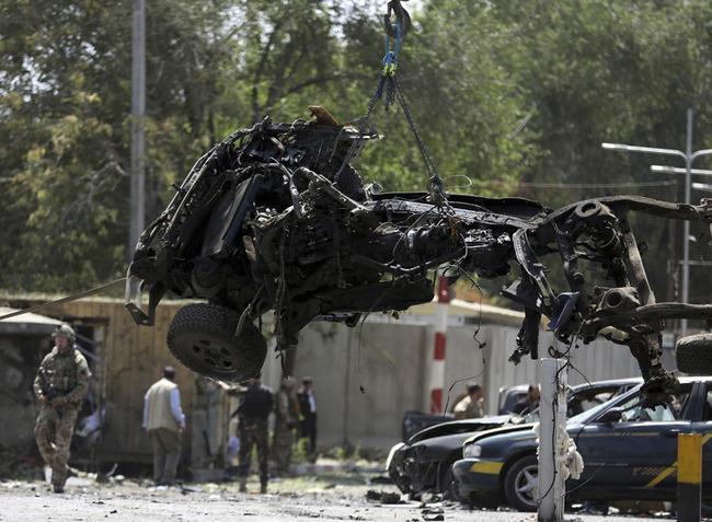 In this Sept. 5, 2019 photo, Resolute Support (RS) forces remove a destroyed vehicle after a car bomb explosion in Kabul, Afghanistan. An American service member was killed in action on Monday in Afghanistan the U.S. military said in a statement without providing more details. [Photo: AP/Rahmat Gul]