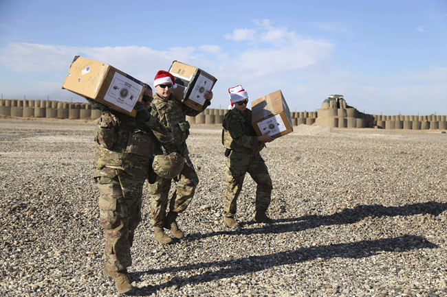 In this Tuesday, Dec. 24, 2019, photo, U.S. service members deliver Christmas gifts to their comrades on a base near the al-Omar oilfield in eastern Syria. [Photo: AP]<br>