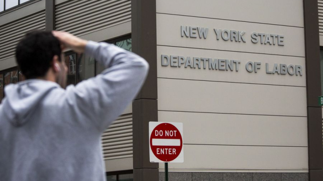 Chodec stojí před úřadem práce státu New York, New York, Spojené státy, 8. května 2020. / Xinhua