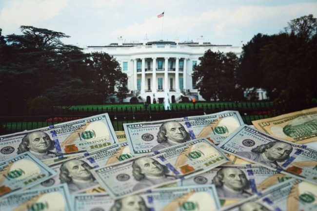Americké dolarové bankovky a obraz Bílého domu jsou uspořádány pro fotografii ve Washingtonu D.C., USA, 20. srpna 2019. (Xinhua / Liu Jie)