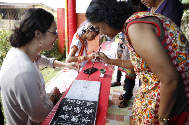 Na snímku někteří Fidžijci nadšeně cvičí čínskou kaligrafii. Fotografie: tisková agentura Nová Čína / Xinhua