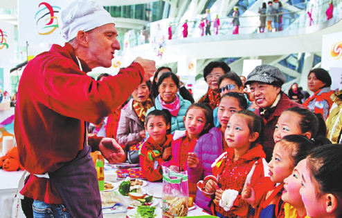 Zahraniční kuchař nabízí pochoutky čínským návštěvníkům v nákupním centru v obvodě Chaoyang (Čchao-jang) v Pekingu. V silné mezinárodní atmosféře se v tomto městském obvodě pořádají pravidelné akce na podporu kulturních výměn. Fotografie: Hu Kaj (Chu kaj pro deník China Daily