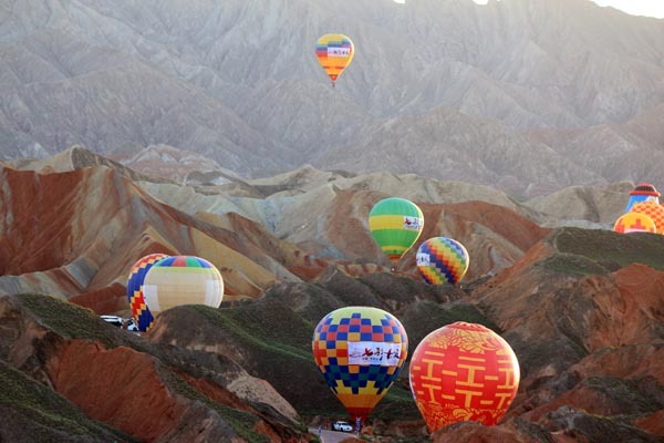 Na snímku jsou horkovzdušné balóny v národním geologickém parku Danxia (Tan-sia) v Zhangye (Čang-jie) v Gansu. Fotografie: Chen Xuelei (Čchen Süe-lej) pro deník China Daily