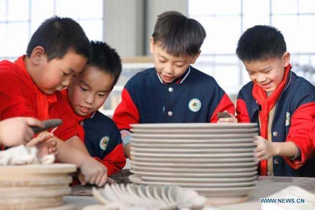 4, Žáci základních škol zkouší výrobu porcelánu v dílně porcelánu Ru (Žu) v okrese Baofeng (Pao-feng) v provincii Henan (Che-nan) ve střední Číně. Okres Baofeng je známý výrobou porcelánu Ru, jednoho z pěti známých porcelánů během dynastie Song (Sung, 960-1279) ve starověké Číně. Více než 90 studentů základní školy Xichengmen (Si-čcheng-men) v okrese Baofeng se zde v neděli zúčastnilo praktické aktivity, kde se dozvěděli o porcelánu Ru. (Foto He Wuchang / Xinhua)