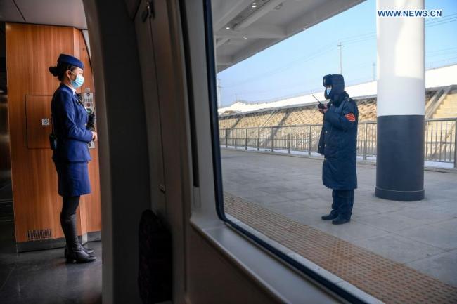 Šéfka průvodčích Dong Fang (Tung Fang) hovoří se zaměstnancem na nádraží Tianshuibu (Tchien-šuej-pu) během zkušebního provozu vysokorychlostní železnice Yinchuan (Jin-čchuan) - Xi'an (Si-an), 12. prosince 2020. Vysokorychlostní železnice Yinchuan-Xi'an se chystá být uvedena do provozu. (Xinhua / Feng Kaihua)