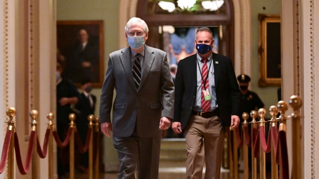 Vůdce většiny Senátu USA Mitch McConnell (L) prochází americkým Kapitolem ve Washingtonu, 16. prosince 2020. / Reuters