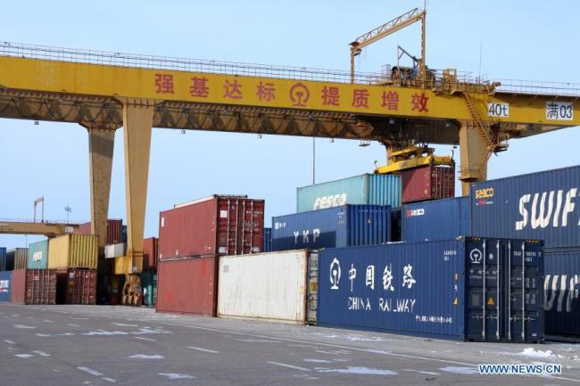 Fotografie pořízená 5. ledna 2021 ukazuje portálový jeřáb zvedající kontejner v Manzhouli v severočínské autonomní oblasti Vnitřní Mongolsko. Počet čínsko-evropských nákladních vlaků, které přijíždějí a odjíždějí přes Manzhouli, největší čínský pozemní přístav, dosáhl v roce 2020 rekordu i přes dopad COVID-19, uvedly ve středu místní železniční úřady. (Foto: Guo Nailun / Xinhua)