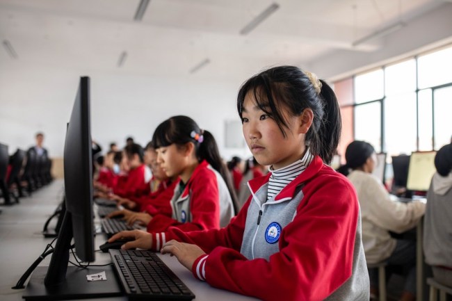 Počítačová třída ve škole v místě pro přesídlení na pomoc proti chudobě v okrese Zhenxiong (Čen-siong) ve městě Zhaotong (Čao-tchung) v provincii Yunnan (Jün-nan) v jihozápadní Číně, dne 24. září 2020. Fotografie: tisková agentura Nová Čína / Xinhua