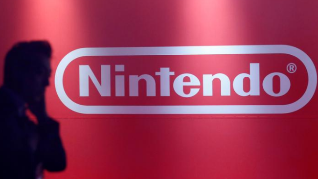 Na slavnostním představení nové herní konzole Switch v japonském Tokiu 13. ledna 2017 stojí muž před logem Nintendo. / Reuters