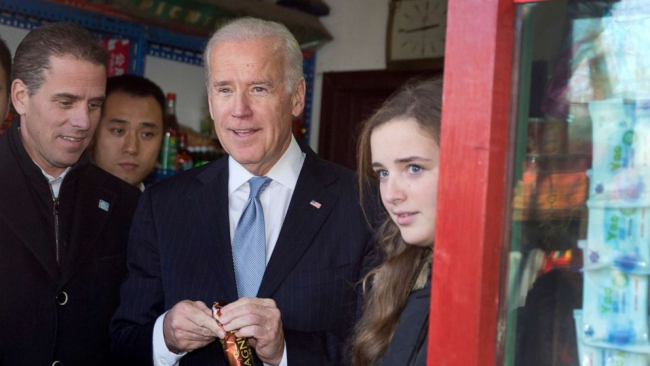 Joe Biden (uprostřed), tehdejší viceprezident USA, kupuje zmrzlinu v obchodě, když cestuje po hutongu se svou vnučkou Finnegan Biden (vpravo) a synem Hunterem Bidenem (vlevo) v čínském Pekingu, 5. prosince 2013. / AP