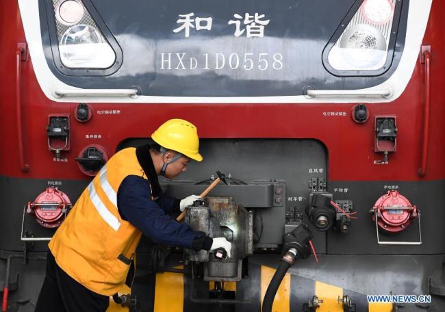 Zaměstnanec společnosti China Railway Zhengzhou Bureau Group Co., Ltd. kontroluje vlak ve městě Zhengzhou (Čeng-čou) v provincii Henan (Che-nan) ve střední Číně, 11. února 2021. Lidé z různých odvětví zastávají své funkce v předvečer čínského lunárního Nového roku, neboli Jarního svátku, který připadá na 12. února. (Xinhua / Li An)