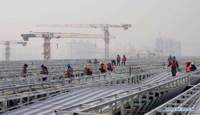 (210211) - PEKING, 11. února 2021 (Xinhua) - Pracovníci pracují na staveništi na nádraží Fengtai (Feng-tchaj) v obvodu Fengtai v Pekingu, hlavním městě Číny, 11. února 2021. Lidé z různých odvětví zastávají své funkce v předvečer čínského lunárního Nového roku, neboli Jarního svátku, který připadá na 12. února. (Xinhua / Wang Yuguo)